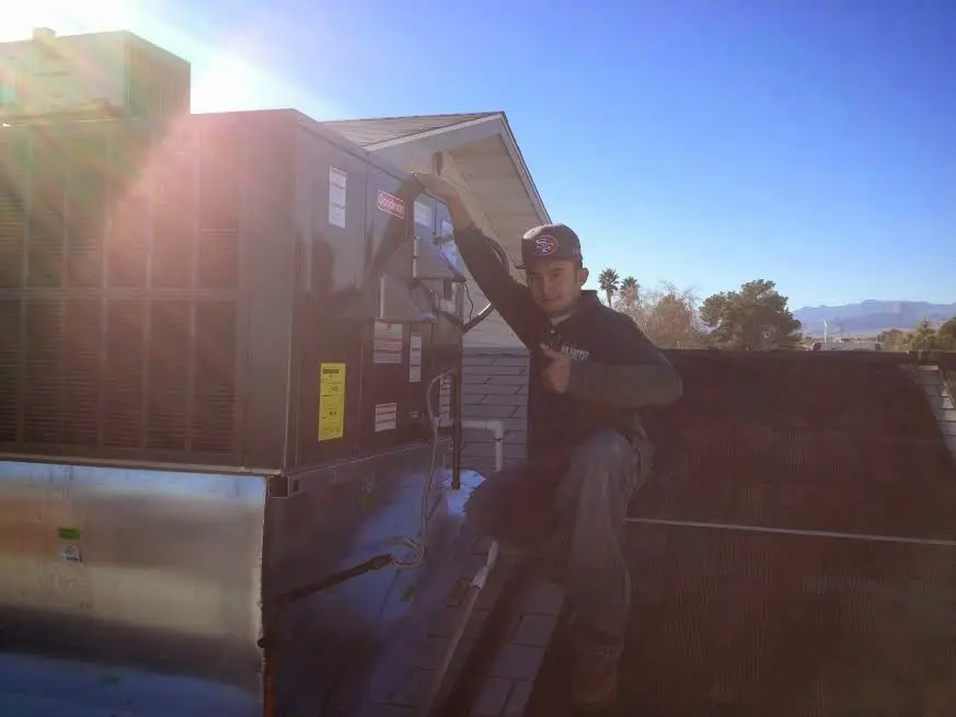 HVAC technician performing Boiler Repair on a rooftop unit in Lindon